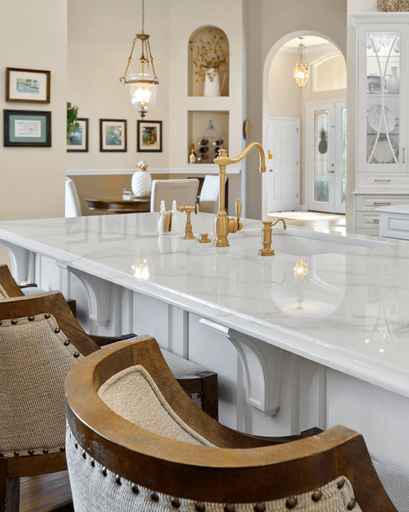 Luxury kitchen with large white marble countertop and gold fixtures