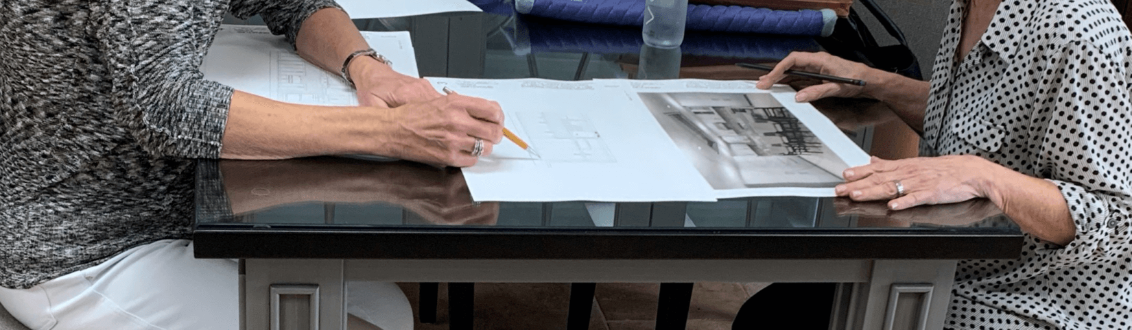 Two people drawing renderings of custom home kitchen design