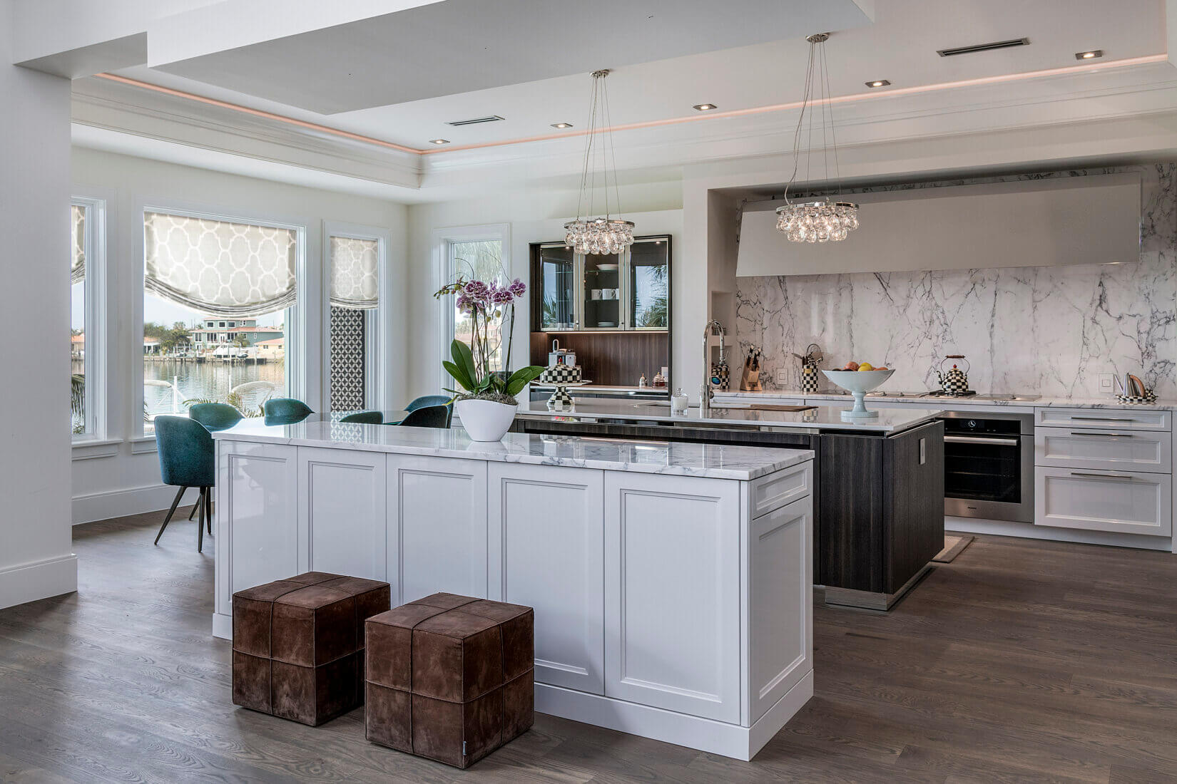 Upscale kitchen with white and dark-wood cabinetry and marble backsplash