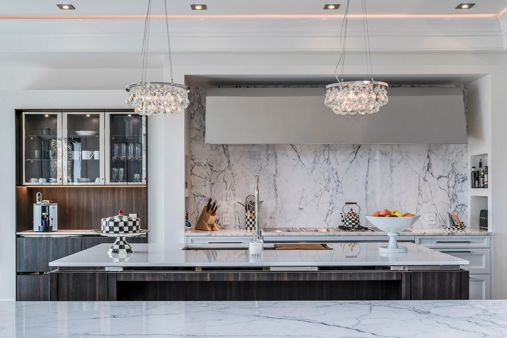 Elegant kitchen with white marble backsplash and glass chandeliers
