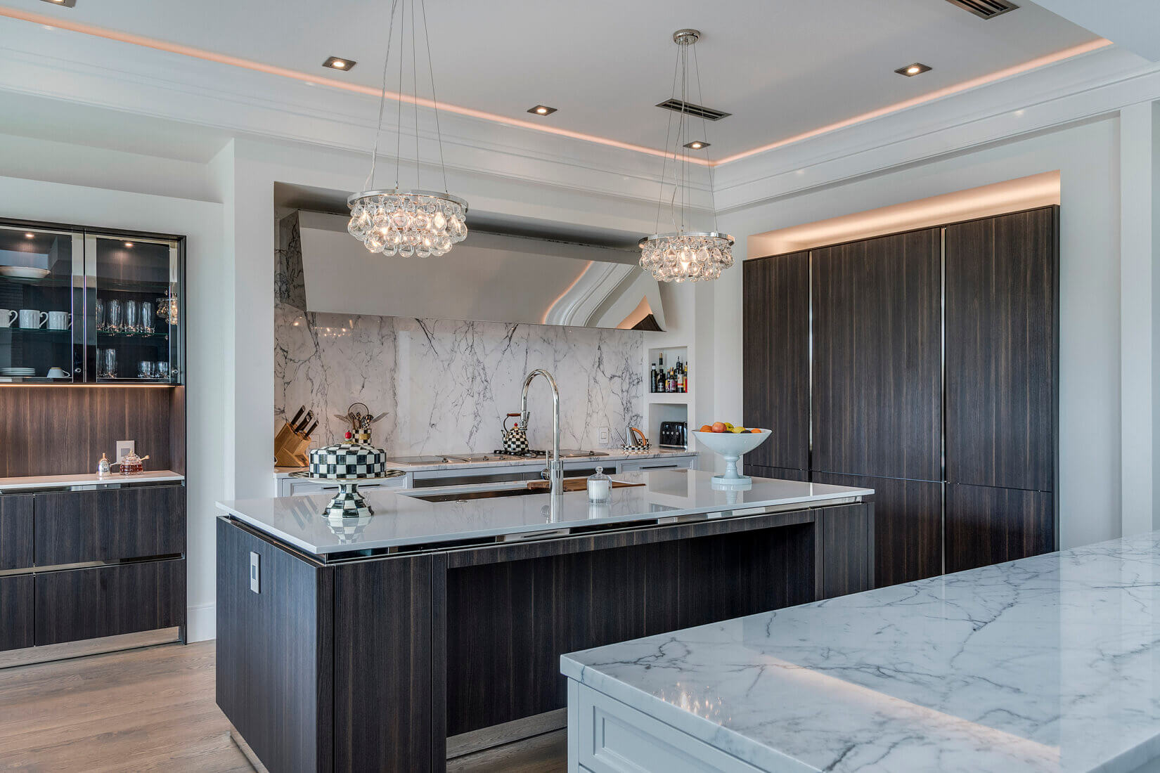 Elegant kitchen with white marble backsplash and dark cabinetry