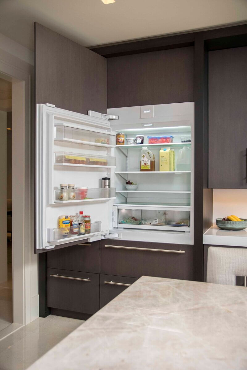 Custom refrigerator built into dark-wood cabinetry