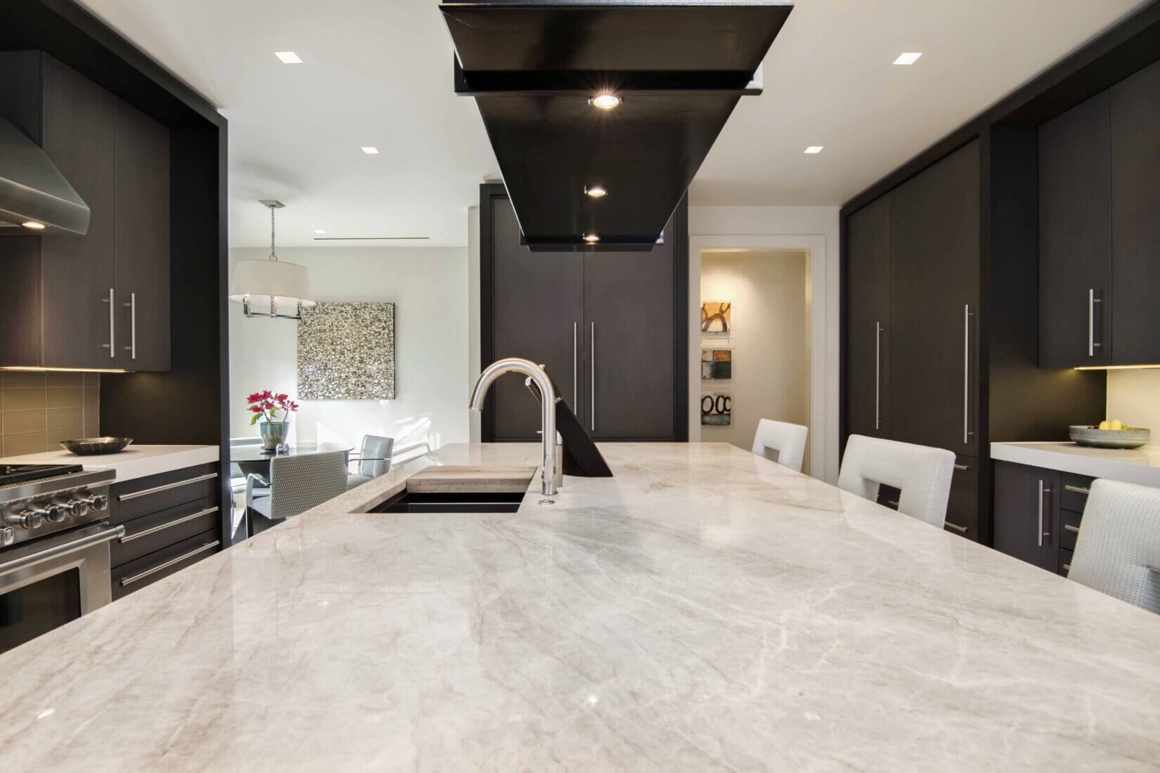 Luxury kitchen with dark-wood cabinetry and white marble counters