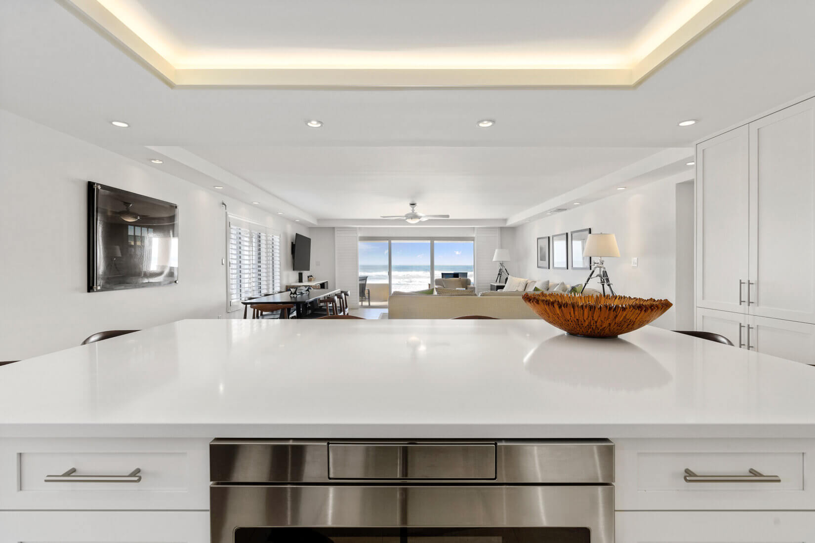 Sleek white kitchen design with large island countertop and modern lighting