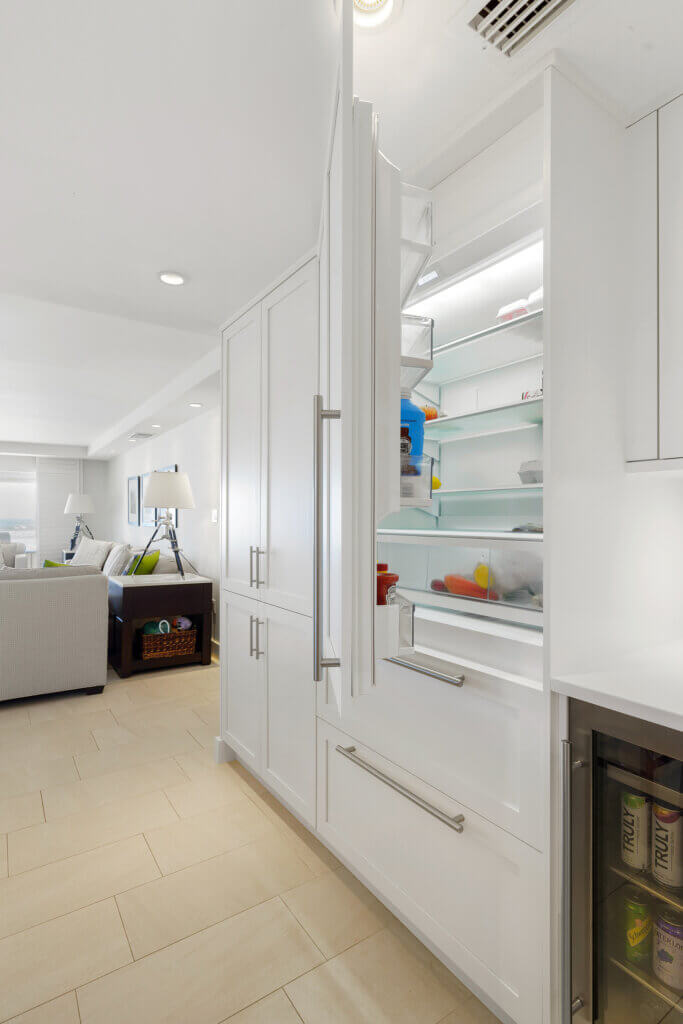 Luxury refrigerator installed within white kitchen cabinetry