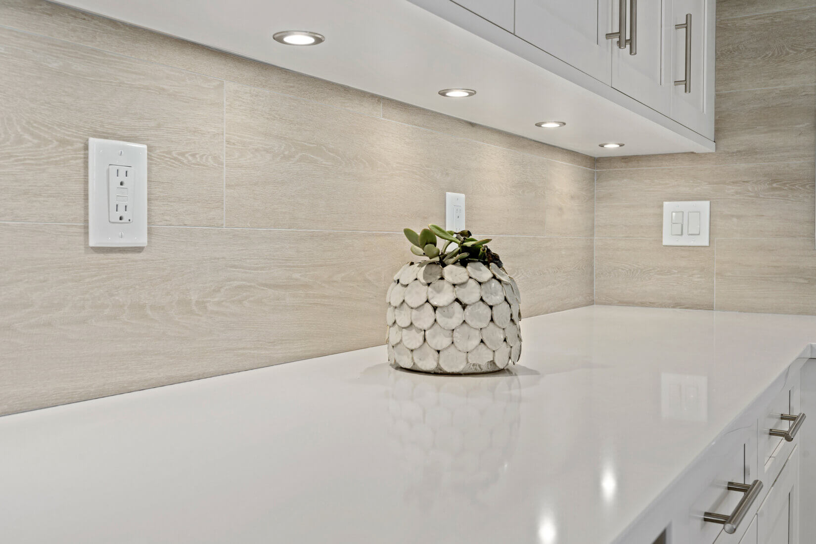 Sleek white countertop with light wood-grain backsplash