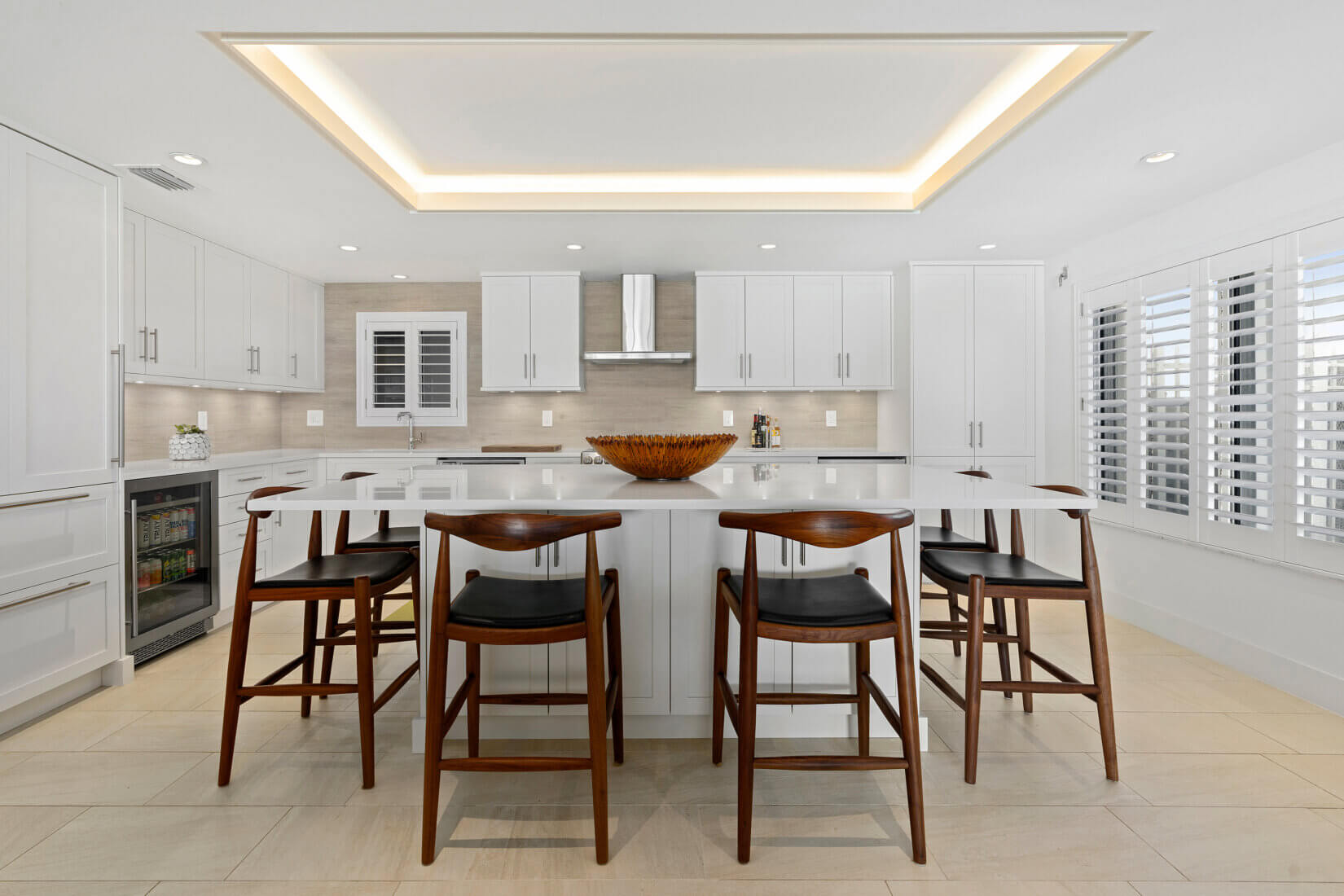 Sleek white kitchen design with island and surrounding seating