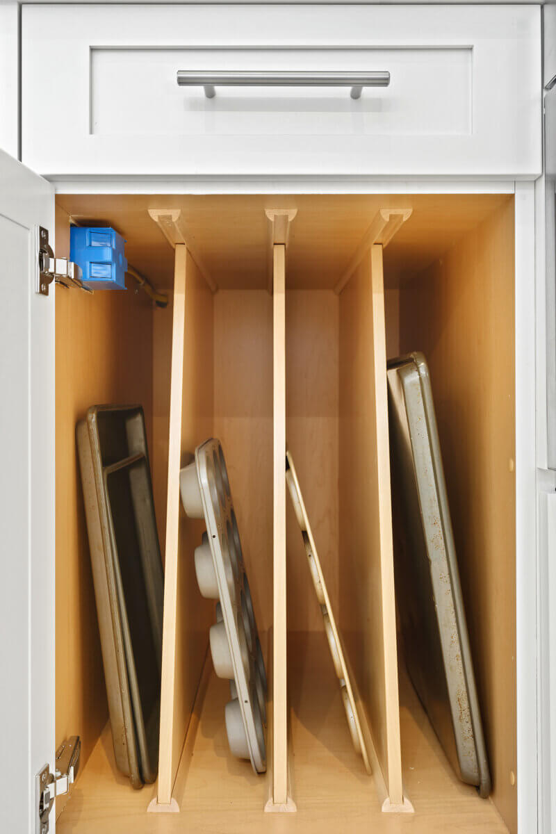Closeup of inside a luxury white cabinet with dividers for cooking sheets