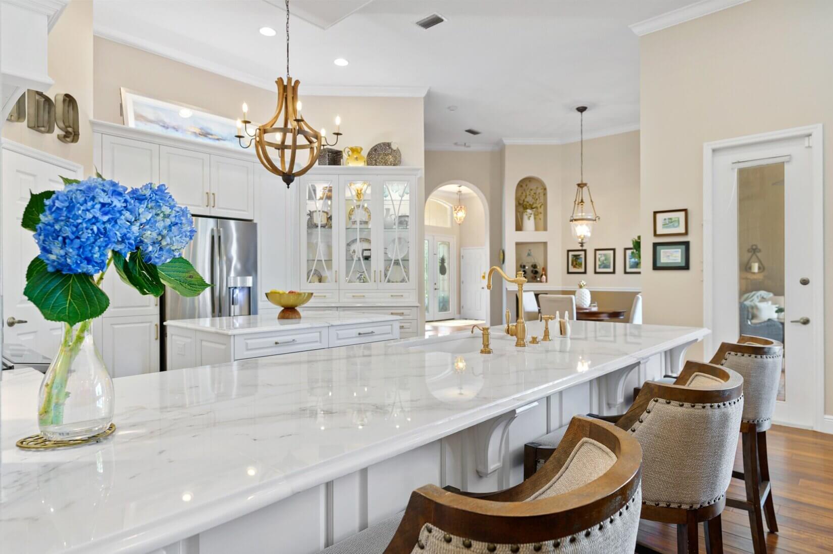 Large luxury kitchen with white cabinetry and white marble counters