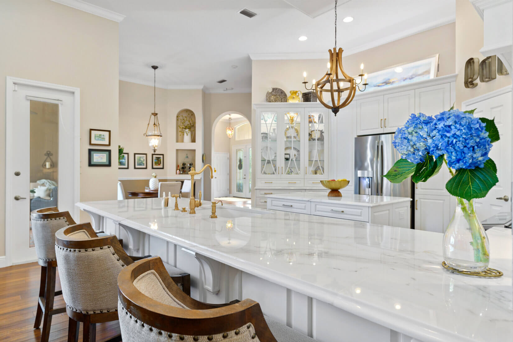 Luxury home kitchen design with white kitchen counter with brown bar stools